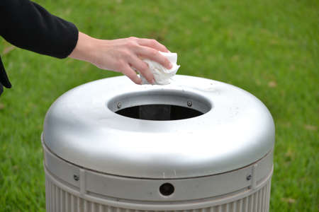 Hand throwing a paper in the trashの写真素材