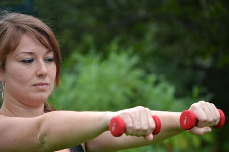  Woman with dumbbells in the parkの写真素材