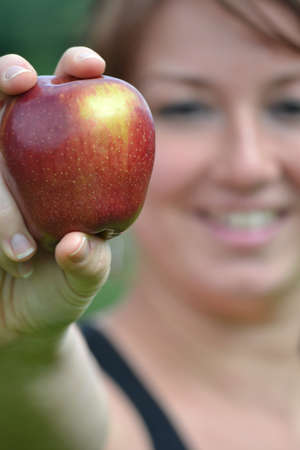 young woman showing an appleの写真素材