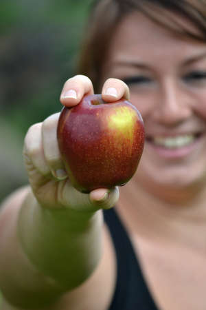 young woman showing an appleの写真素材