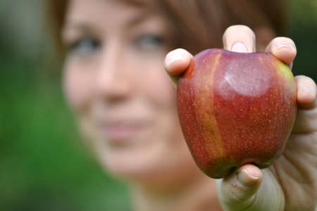 young woman showing an appleの写真素材