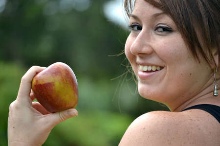 young woman showing an appleの写真素材