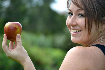 young woman showing an appleの写真素材