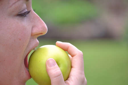 Young woman eating an appleの写真素材