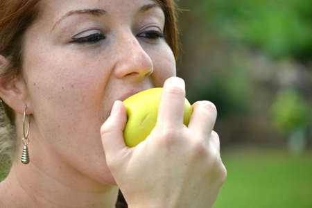 Young woman eating an appleの写真素材