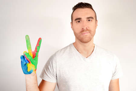 Young man making victory sign with his handの写真素材