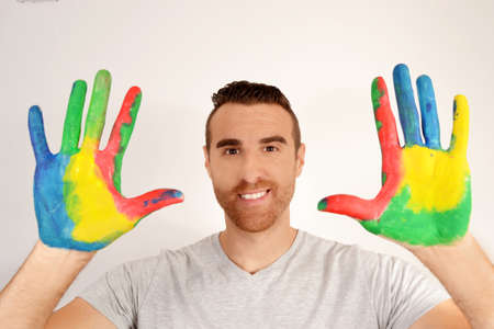 Man looking into the camera with painted handsの写真素材