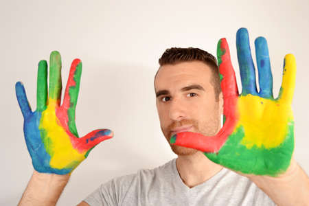 Man looking into the camera with painted handsの写真素材