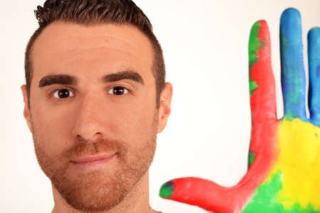 Man looking into the camera with painted handsの写真素材