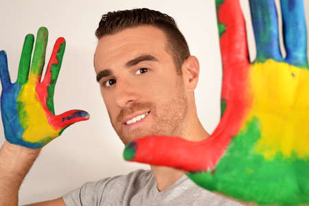 Man looking into the camera with painted handsの写真素材
