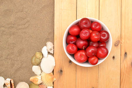 Plums on wood and sandの写真素材