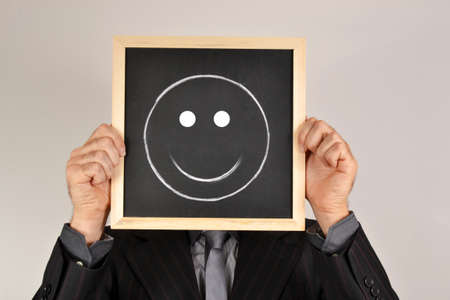 Businessman with smiling face in blackboardの写真素材