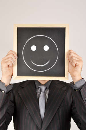 Businessman with smiling face in blackboardの写真素材