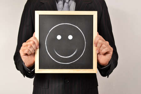 Businessman with smiling face in blackboardの写真素材