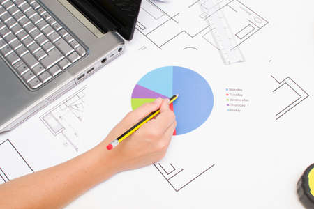 Architect working with plans and laptopの写真素材