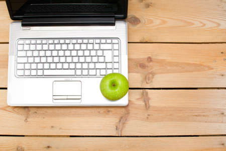The laptop and green appleの写真素材
