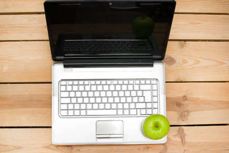 The laptop and green appleの写真素材