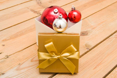 Christmas balls and gift on wood background