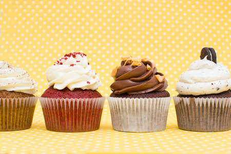 Some cupcakes on yellow backgroundの写真素材