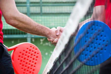 Friends shaking hands in paddle tennisの写真素材
