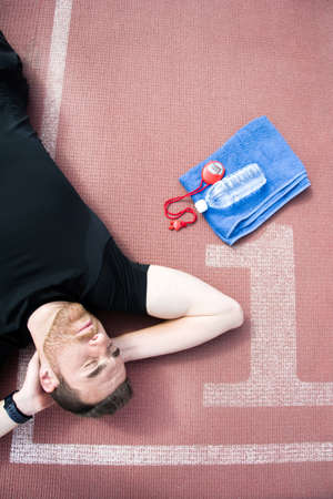 Man lying on the running trackの写真素材