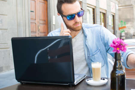 young man with a laptop and a coffeeの写真素材