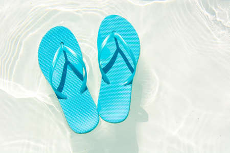 summer shoes afloat in the swimming poolの写真素材