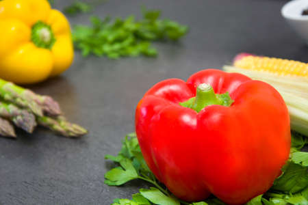 Peppers and other vegetables on slate tableの写真素材