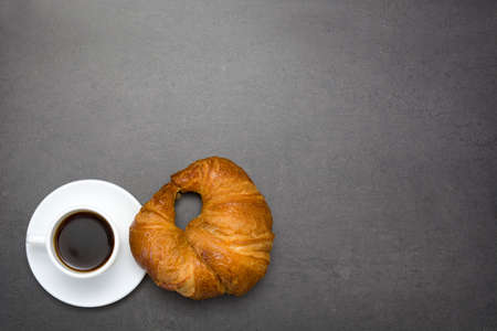 Coffee and croissant on slate tableの写真素材