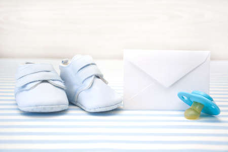 Baby shoes, letters, pacifier and paper envelopeの写真素材