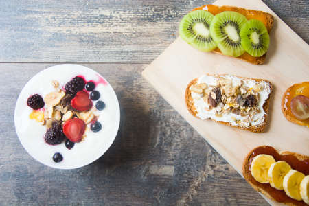 Natural yogurt with fresh berries, toast with fruit and cerealsの写真素材