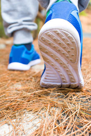 Young man exercising on the road with autumn landscape backgroundの写真素材
