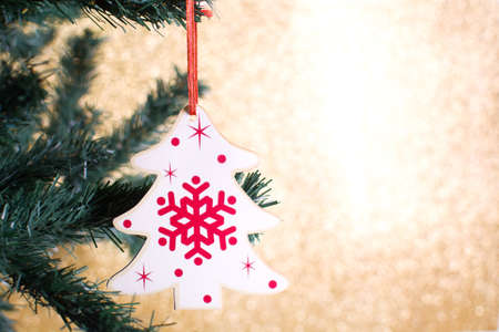 Christmas decoration with tree shape on the Christmas tree with golden glitter backgroundの写真素材