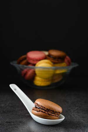 Macaron in a spoon. Black backgroundの写真素材