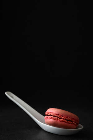 Macaron in a spoon. Black backgroundの写真素材
