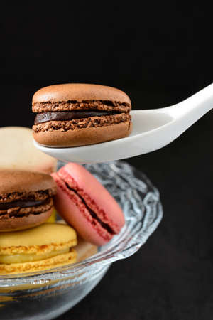 Macaron in a spoon. Black backgroundの写真素材