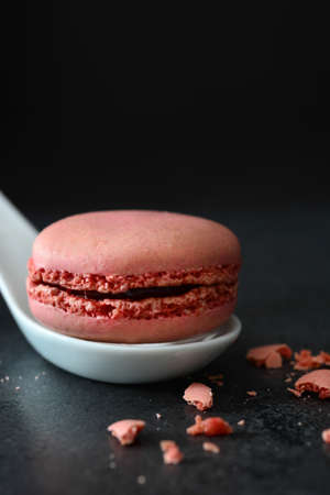 Macaron in a spoon. Black backgroundの写真素材