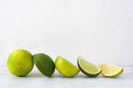 Limes on a white wood tableの写真素材