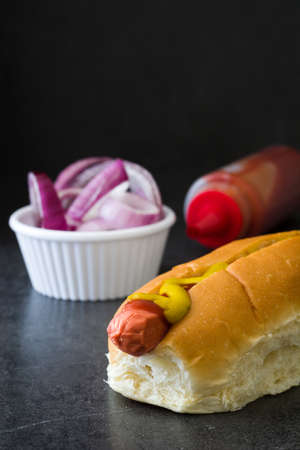Hot dog with mustard and ketchup on black backgroundの写真素材