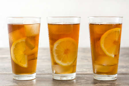 refreshing iced tea with lemon on wood