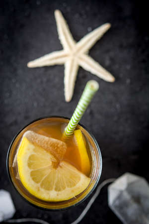 Ice tea with lemon. Black stone