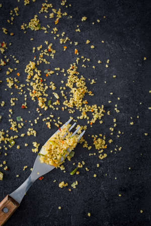 With couscous Fork on black stone backgroundの写真素材