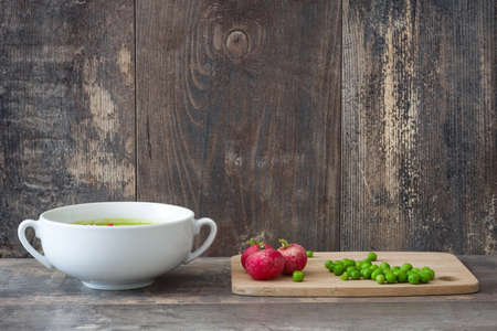 Pea cream with radishes on a rustic wooden backgroundの写真素材