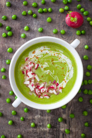 Peas cream with radishes on rustic wooden tableの写真素材