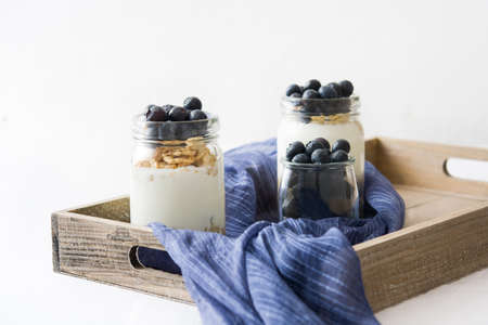 Yogurt with blueberries on white tableの写真素材