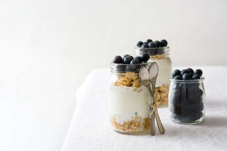 Yogurt with blueberries on white tableの写真素材
