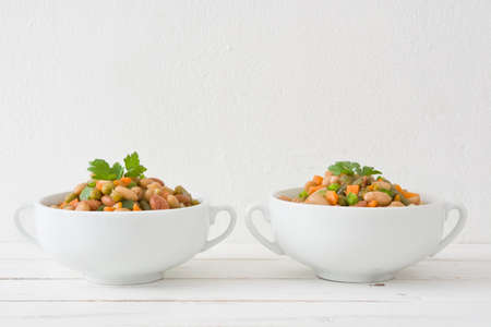 White beans with vegetables on white wooden tableの写真素材