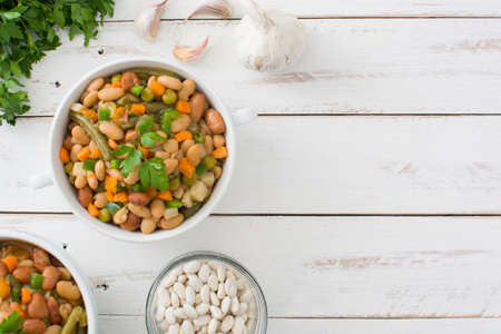 White beans with vegetables on white wooden tableの写真素材