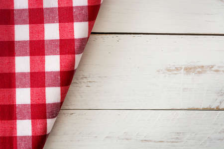 old vintage white wooden table with red checker napkinの写真素材