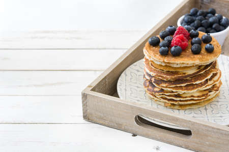 Pancakes with blueberries and raspberry on trayの写真素材